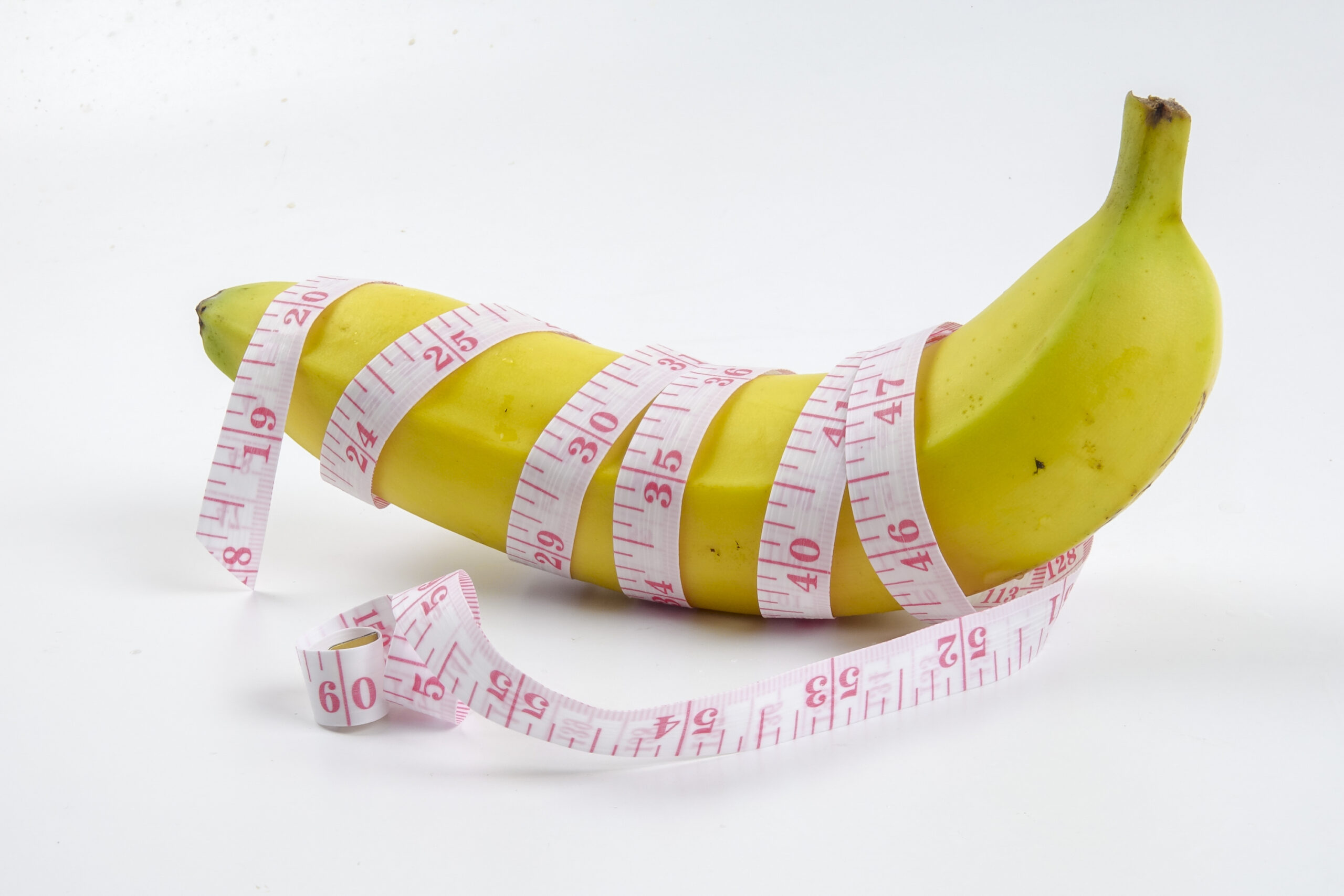 Banana with measuring tape. Menhealth concept